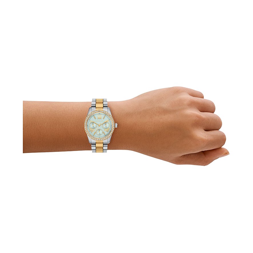Un orologio da donna Michael Kors in acciaio inossidabile al polso, color argento e oro con pietre chiare.