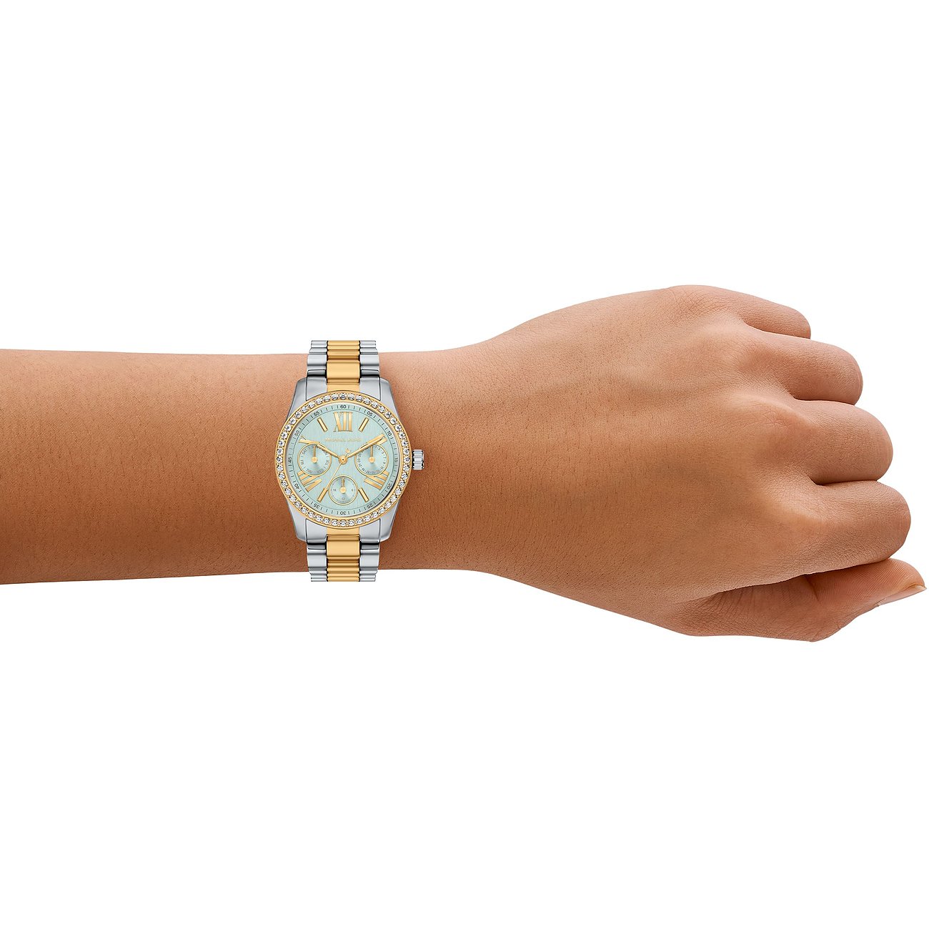 Un orologio da donna Michael Kors in acciaio inossidabile al polso, color argento e oro con pietre chiare.