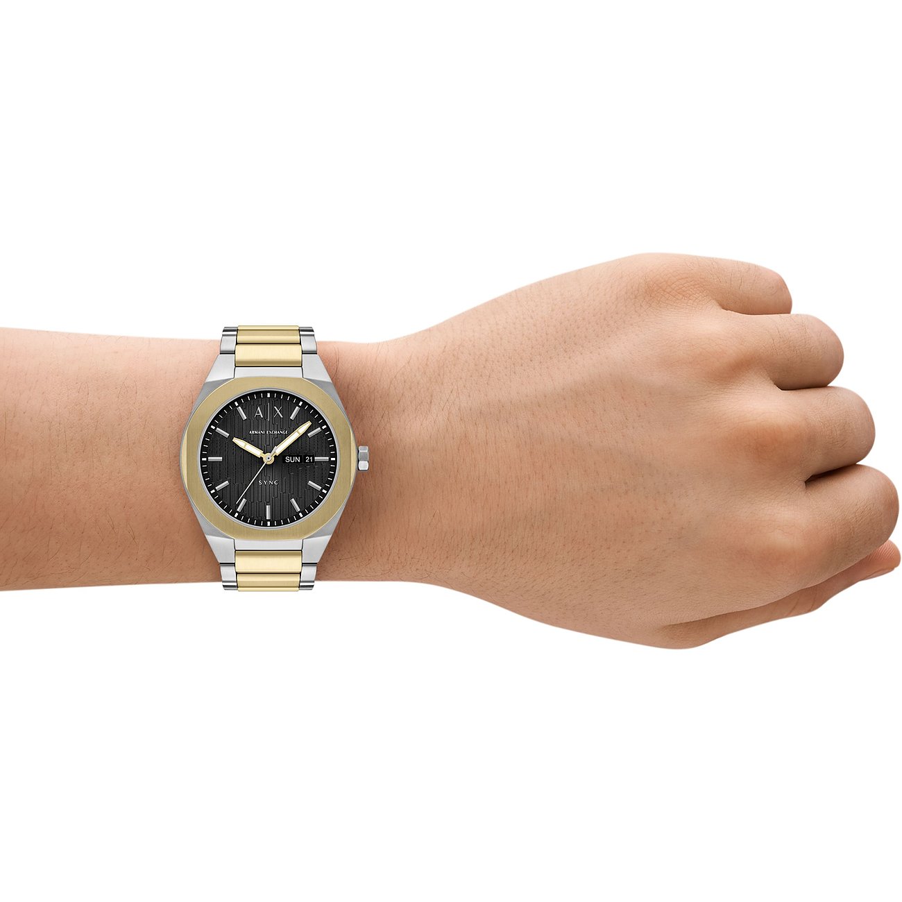 Armani Exchange Herrenuhr aus Edelstahl in Silber und Gold mit schwarzem Zifferblatt am Handgelenk getragen.