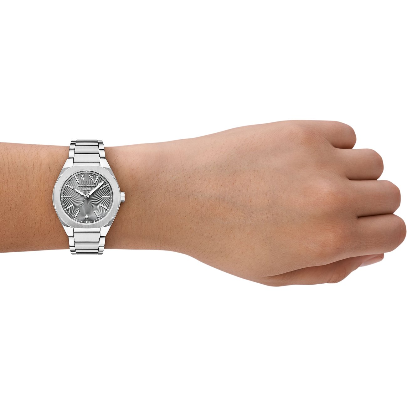 Armani Exchange Damenuhr aus Edelstahl am Handgelenk, mit grauem Zifferblatt und silbernen Indizes, getragen.