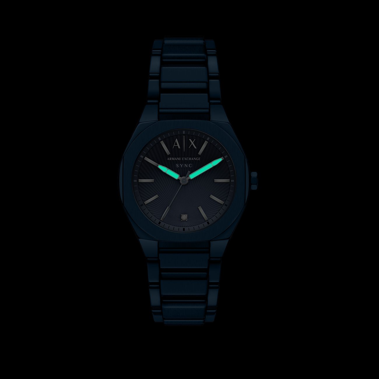 Eine Armani Exchange Damenuhr aus blauem Edelstahl mit leuchtenden Zeigern auf schwarzem Hintergrund.