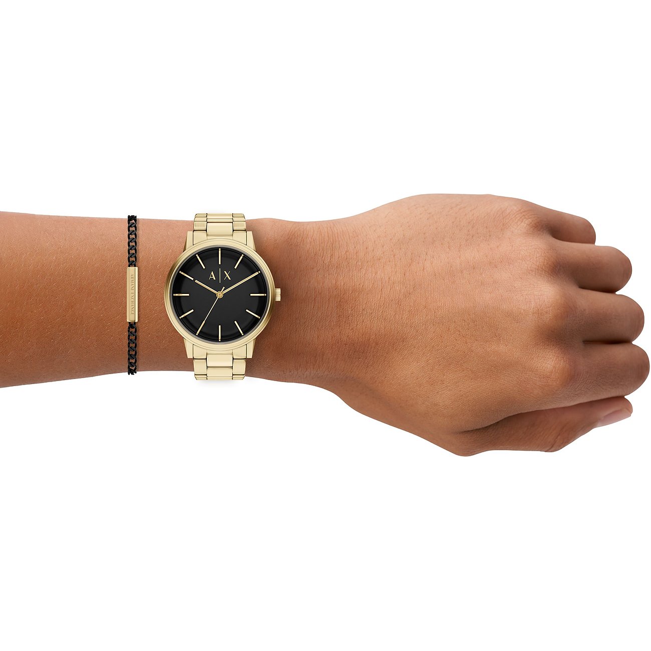 Armani Exchange Uhren-Set aus goldfarbenem Edelstahl mit schwarzem Zifferblatt und passendem Armband am Handgelenk.