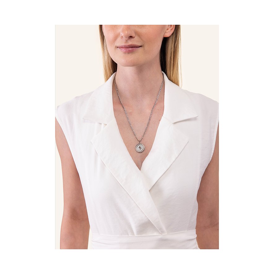 Een vrouw draagt een zilveren Purelei roestvrijstalen ketting met een ronde hanger en een heldere edelsteen.