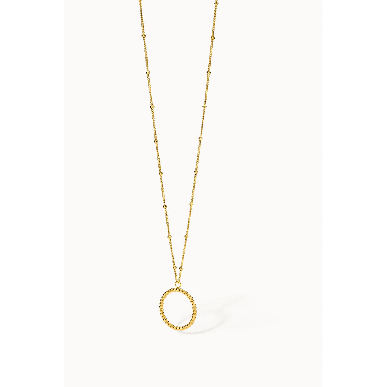 De Purelei-halsketting van goudkleurig roestvrij staal toont een ronde hanger met kleine balletjes aan een ketting.