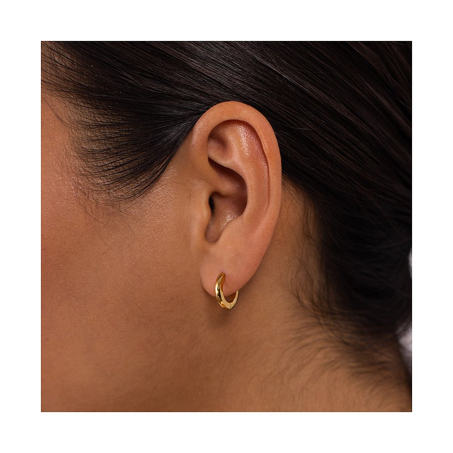 Nahaufnahme eines Ohres mit einem goldenen Creolen-Ohrring aus Edelstahl von Purelei am Ohrläppchen.