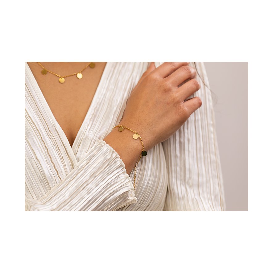 Aan de pols van een vrouw is een Purelei armband te zien, gemaakt van goudkleurig roestvrij staal met ronde hangers.