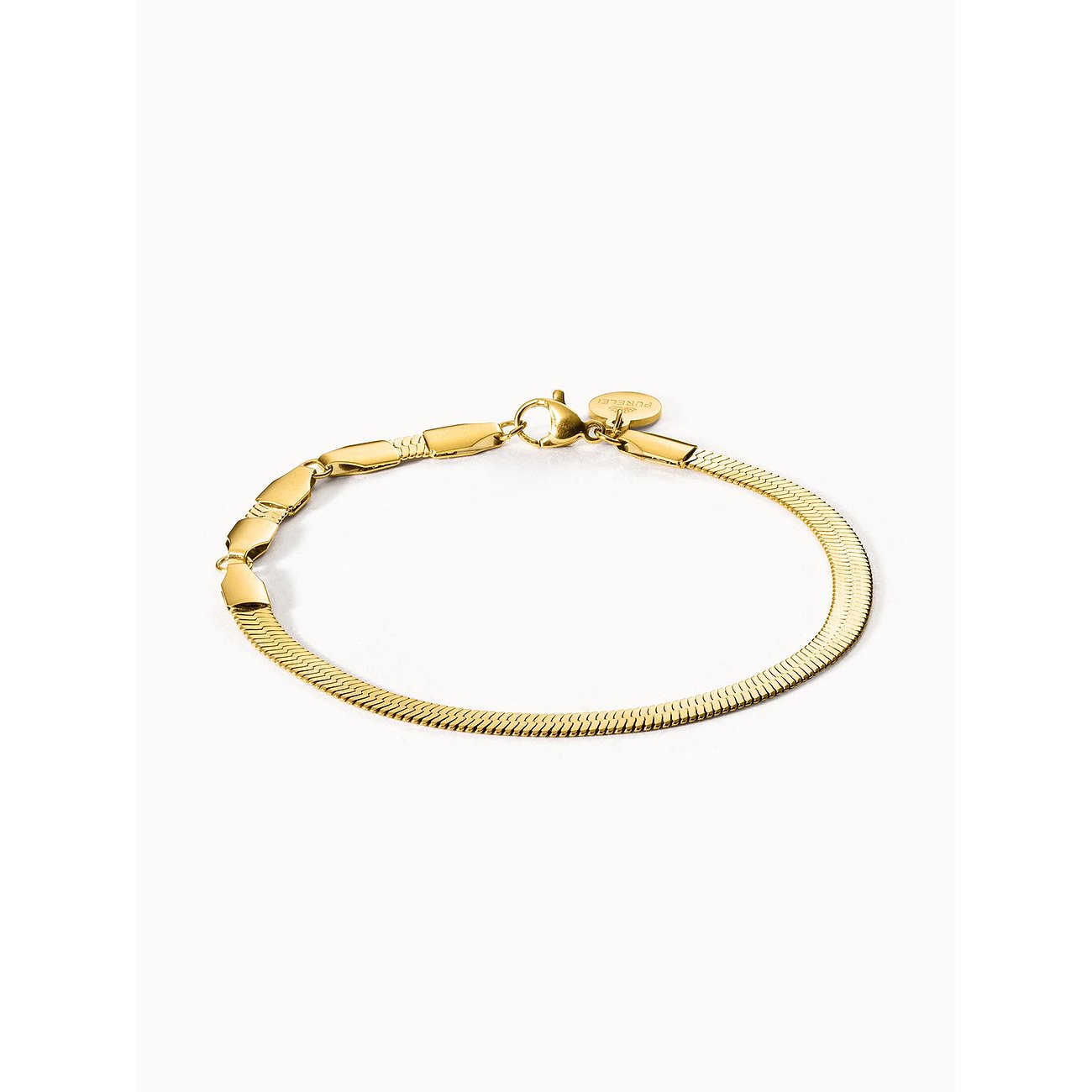 Close-up eines goldenen Purelei Armbands aus Edelstahl, eine Kombination aus Schlangenkette und flachen Gliedern.