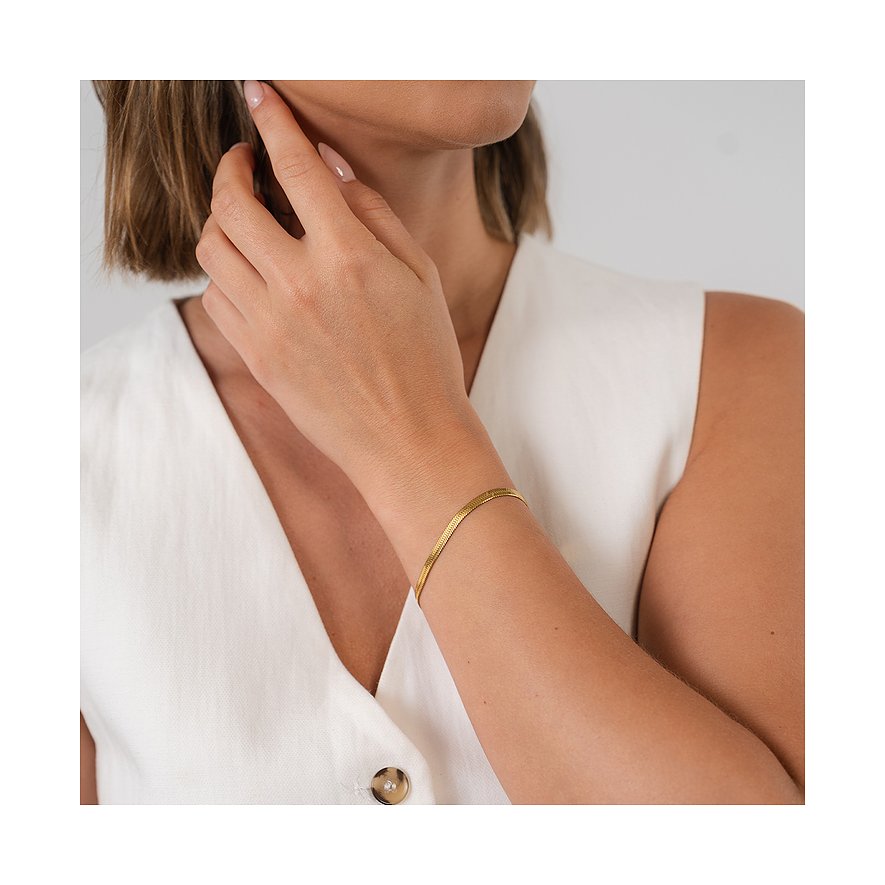 Am Handgelenk einer Frau getragen: ein goldenes Purelei Armband aus Edelstahl mit flacher Schlangenkette.