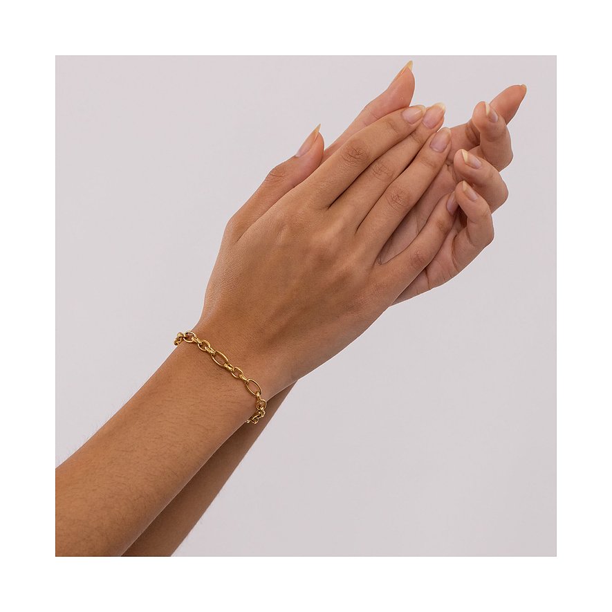 Eine Hand trägt ein goldenes Purelei Armband aus Edelstahl mit verschiedenen Gliedern.