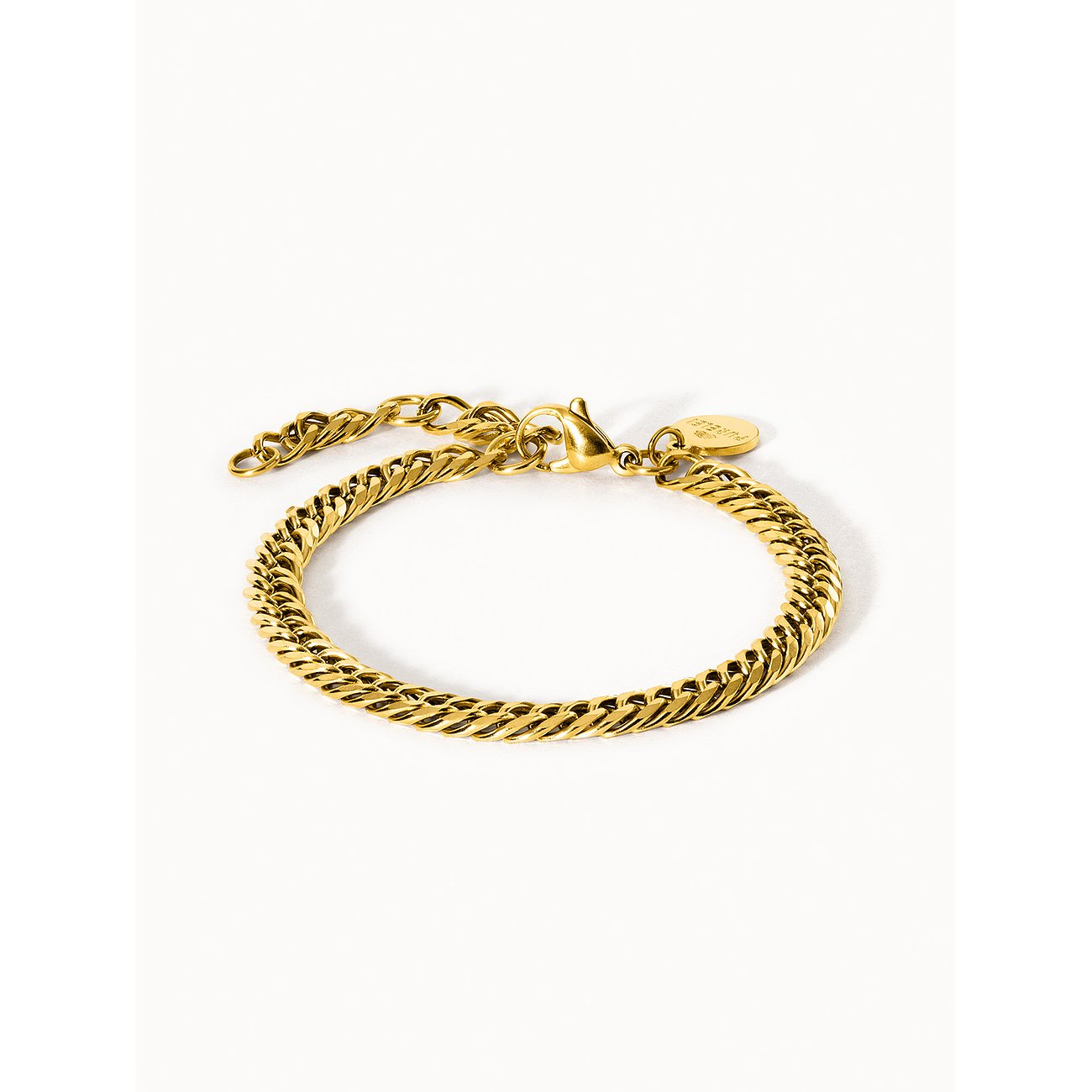 Ein glänzendes, goldenes Purelei Armband aus Edelstahl mit einem eleganten Twist-Design auf weißem Hintergrund.