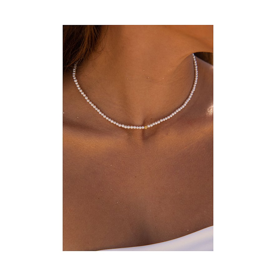 Close-up van een Purelei roestvrijstalen ketting met kleine parels en een enkel gouden accent in het midden.