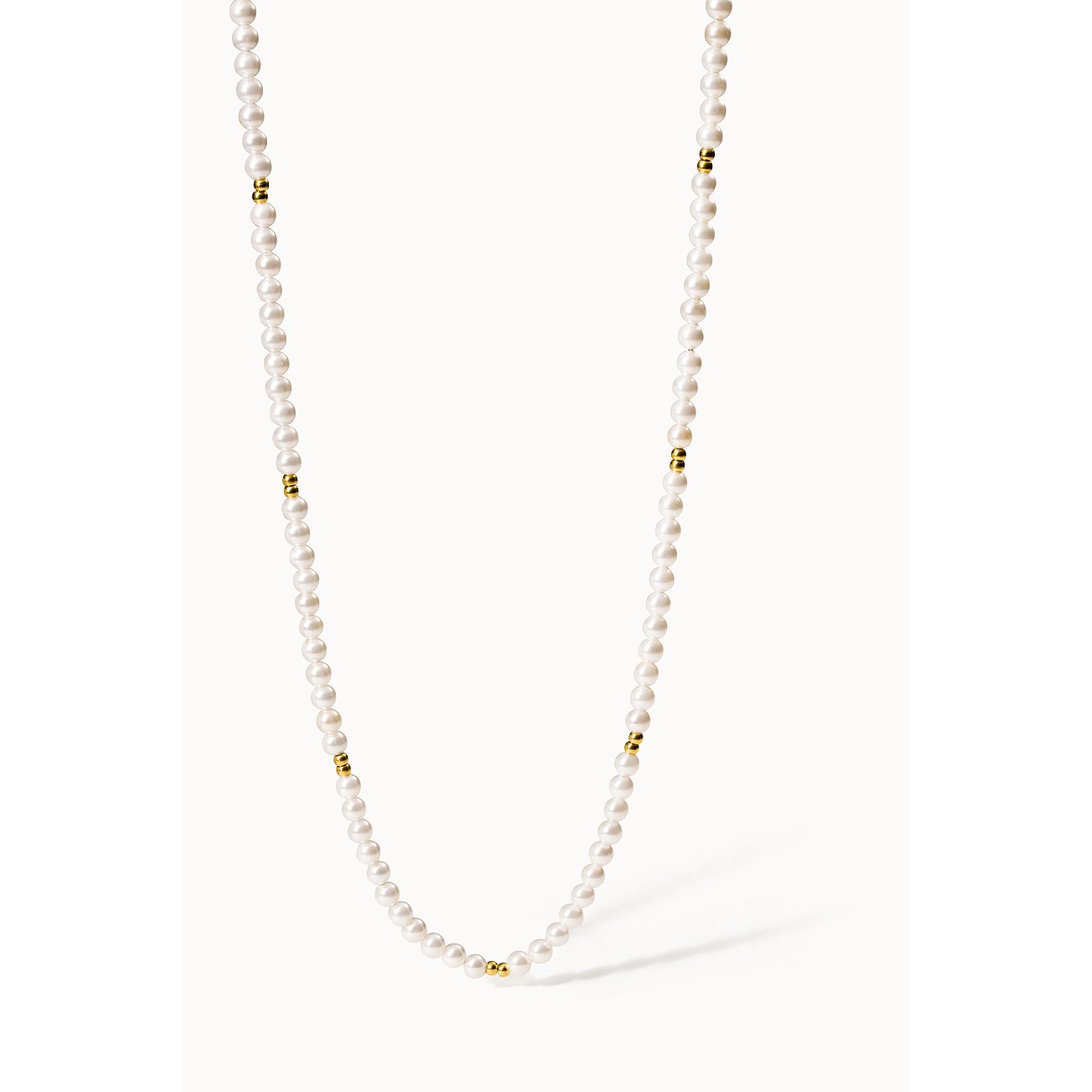 Eine lange Purelei Perlenkette aus Edelstahl mit kleinen goldenen Akzenten. Die Kette ist vertikal aufgereiht.