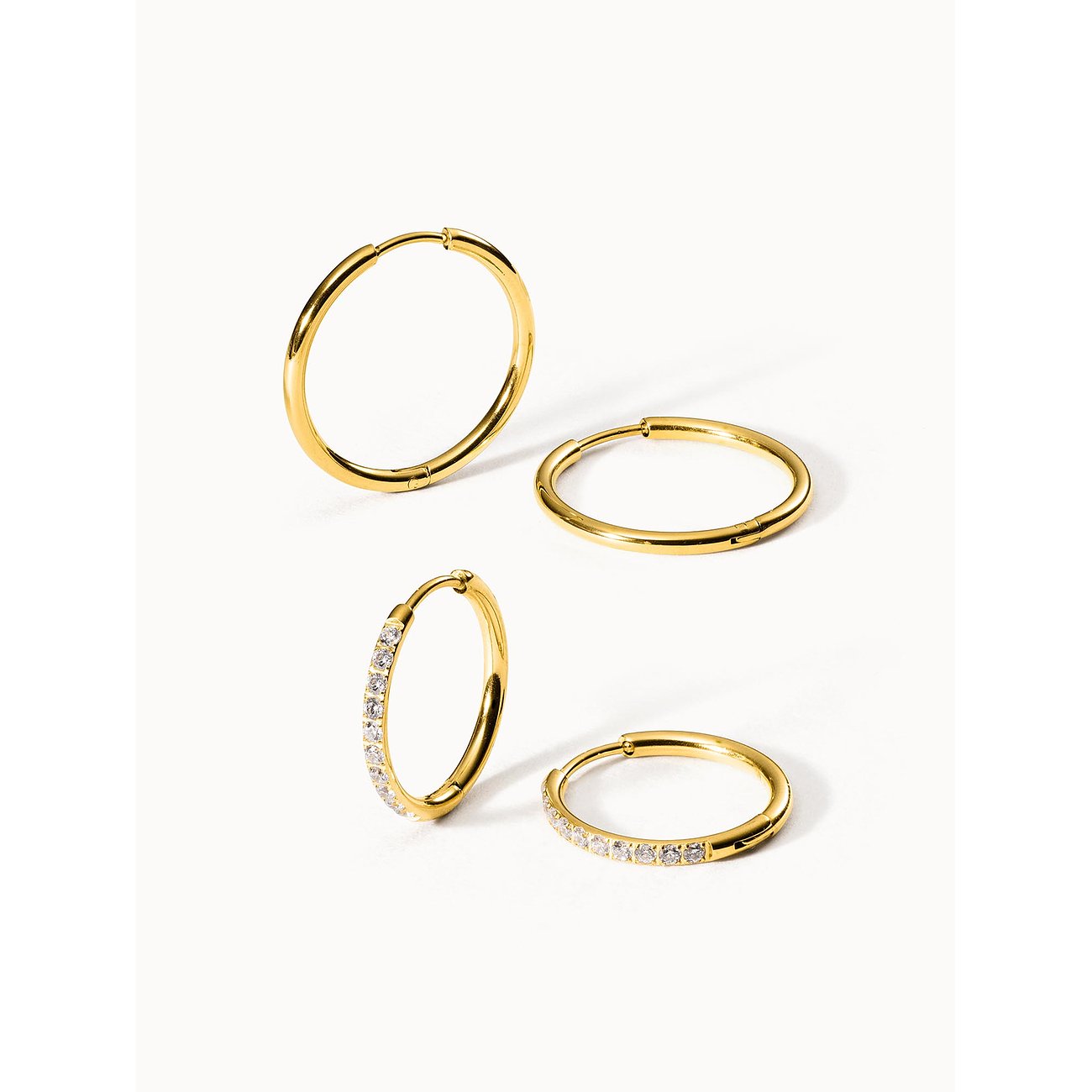 Ein Purelei Set aus vier goldfarbenen Creolen aus Edelstahl Zirkonia. Zwei sind schlicht, zwei mit klaren Steinen besetzt.