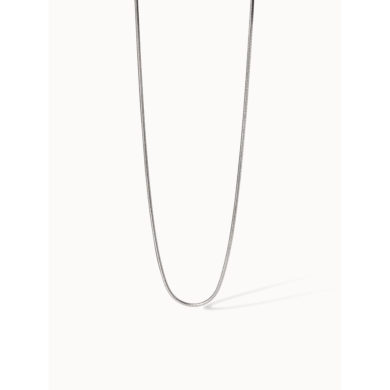 Close-up van een Purelei halsketting van eenvoudig roestvrij staal in slangketting-design, U-vormig hangend.