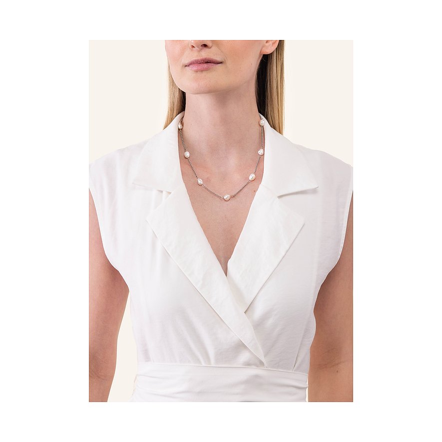 Een vrouw draagt een zilverkleurige Purelei roestvrijstalen ketting met elegante parels.