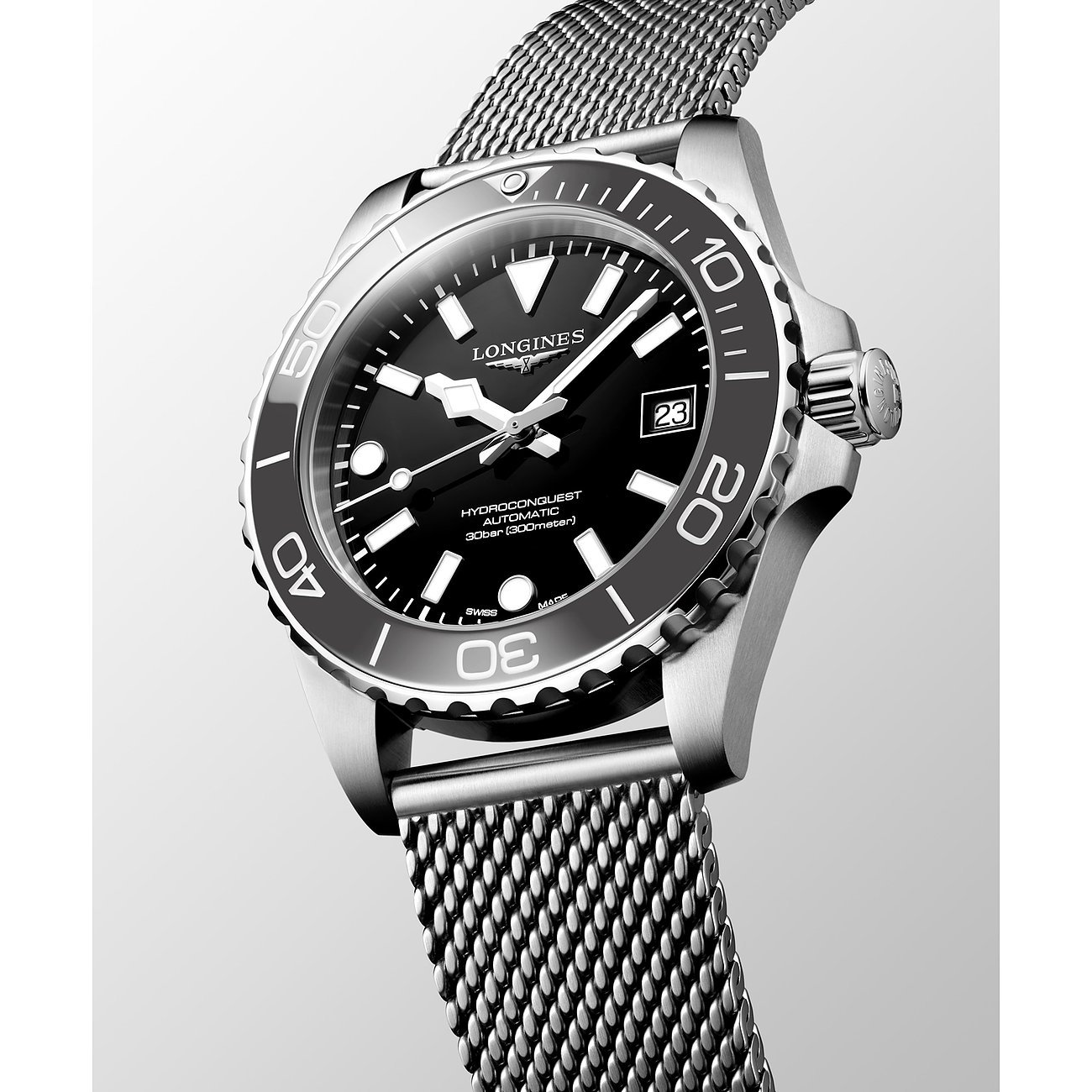 Longines Herrenuhr aus Edelstahl/Keramik, schwarzes Zifferblatt, silberfarbenes Milanaise-Armband, leicht schräg von oben.