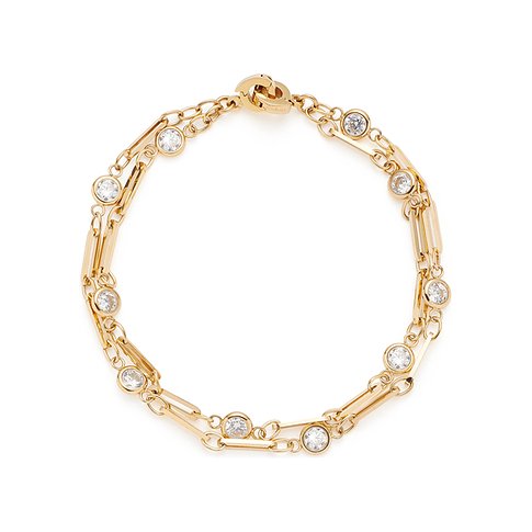 Ein goldenes Armband von Leonardo aus Edelstahl mit runden, klaren Glassteinen, von oben fotografiert.