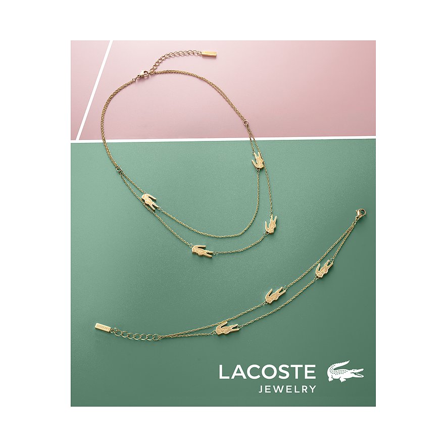 Een gouden Lacoste-armband en een roestvrijstalen halsketting met alligatorhangers liggen op een moderne achtergrond.