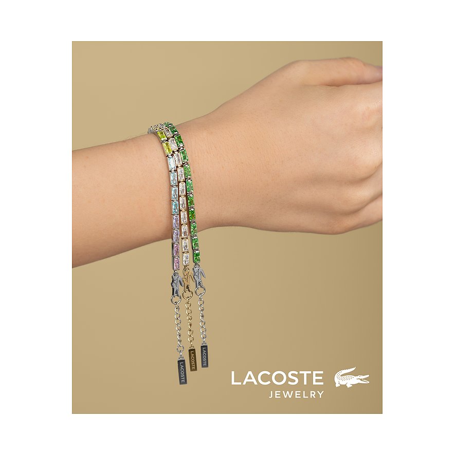 Drie Lacoste armbanden van roestvrij staal met gekleurde zirkonia stenen in diverse groentinten om de pols.