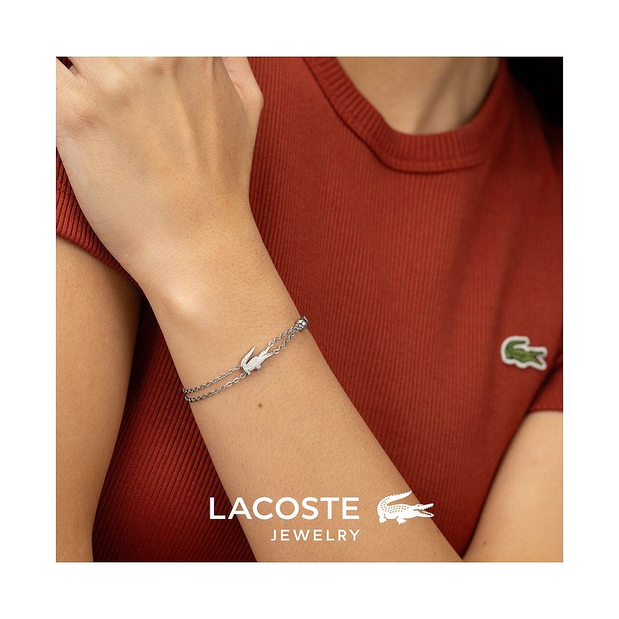 Lacoste armband van roestvrij staal, gedragen om de pols, met een krokodillenbedel en een edelsteen.