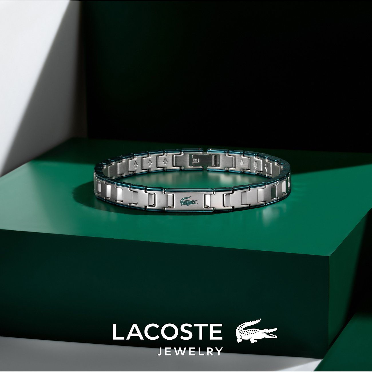 Lacoste roestvrijstalen armband met zilveren en donkerblauwe schakels en het krokodillenlogo