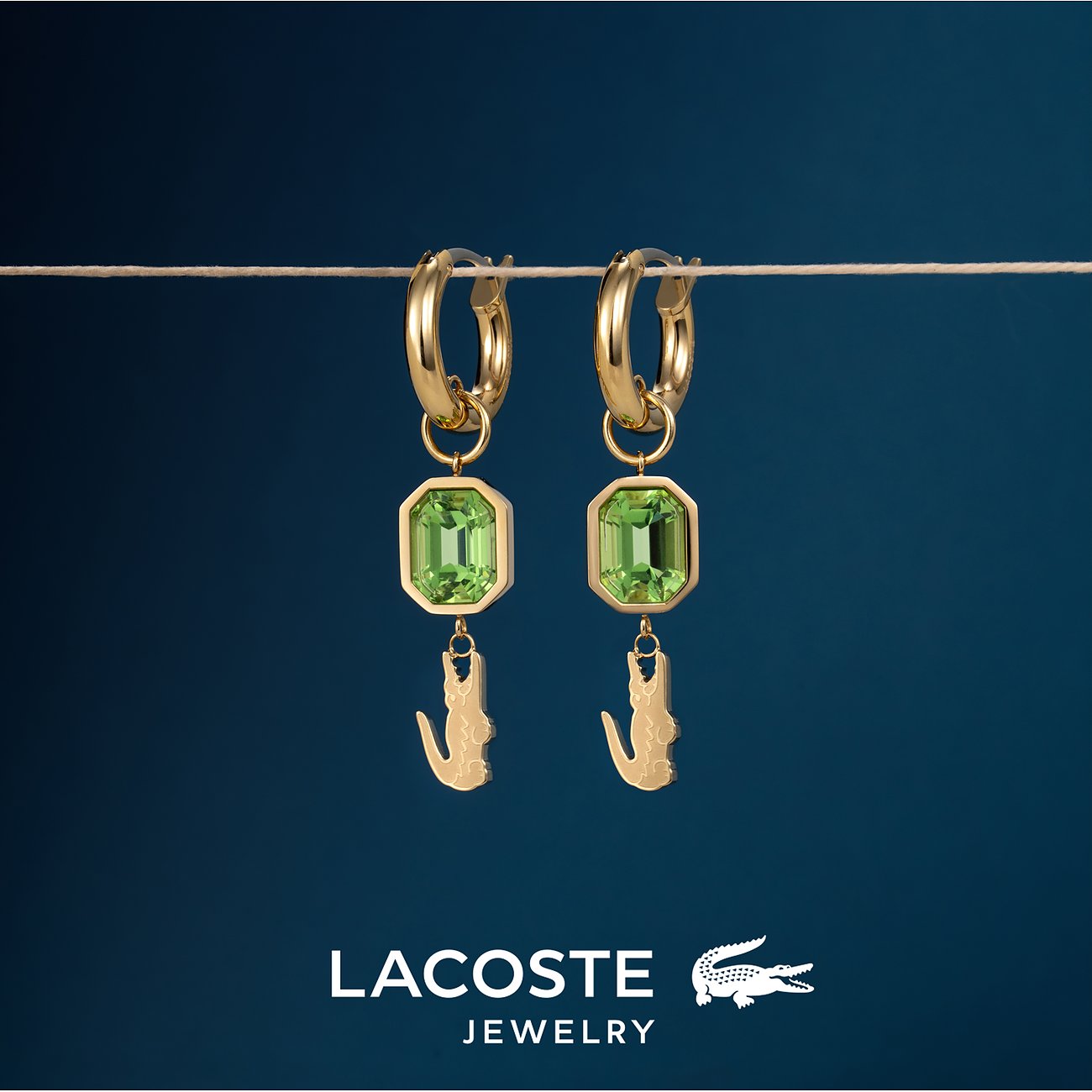 Lacoste creooloorbellen goudkleurig edelstaal met achthoekig groen kristal en krokodilbedel.