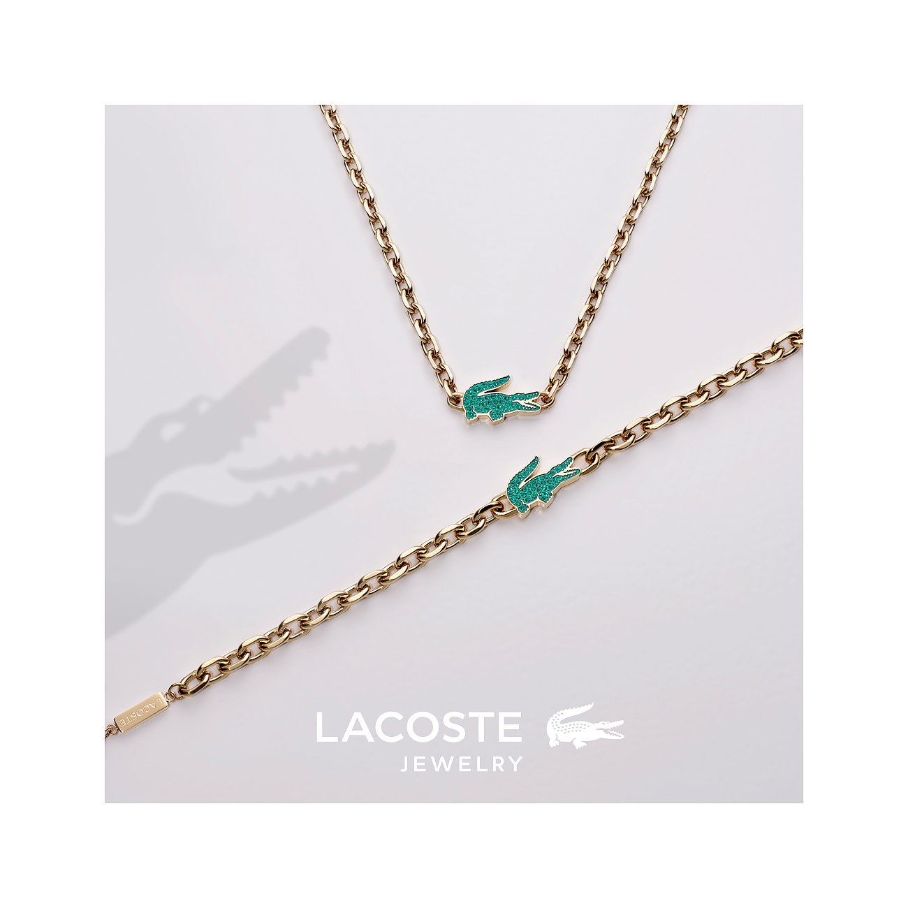 Lacoste Armschmuck und Halskette aus goldfarbenem Edelstahl mit Krokodil-Anhänger aus grünem Kristall.