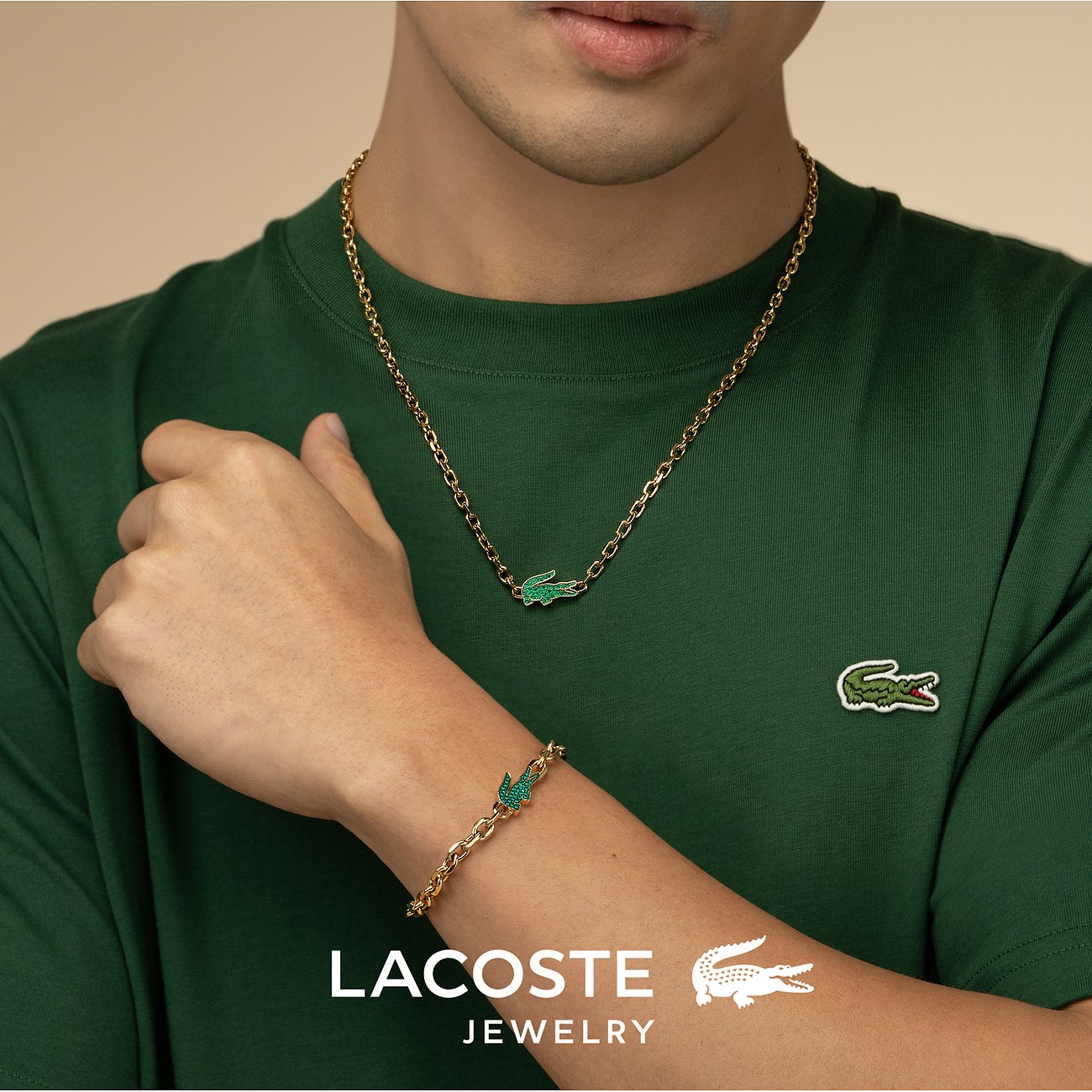 Lacoste Herren-Halskette & Armband: goldfarbener Edelstahl, Krokodilanhänger mit grünen Kristallen.