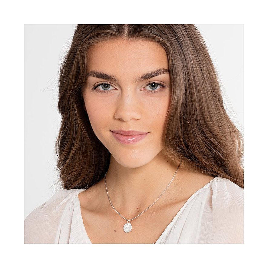 Model trägt eine Thomas Sabo 925er Silber Halskette mit einem runden gravierten Anhänger, der ein Gittermuster zeigt.