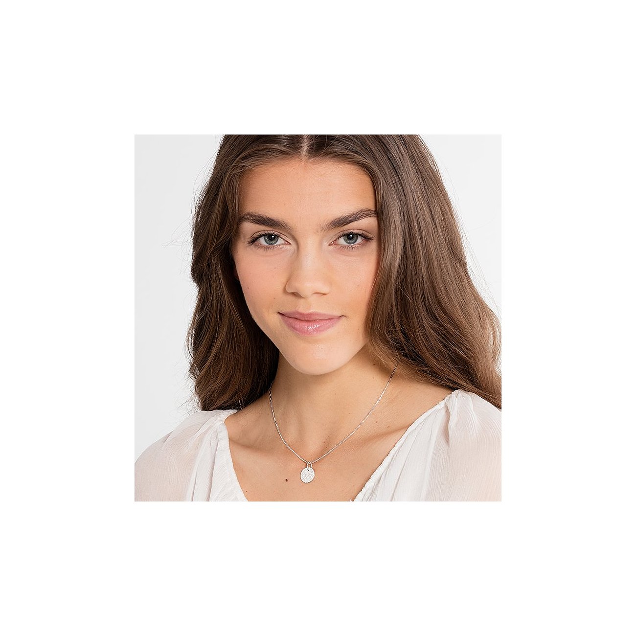 Model trägt eine Thomas Sabo 925er Silber Halskette mit einem runden gravierten Anhänger, der ein Gittermuster zeigt.