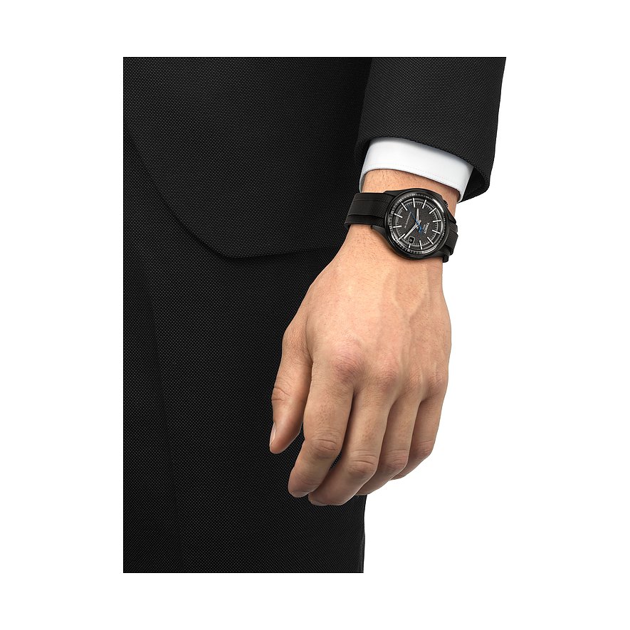 Nahaufnahme einer Tissot Herrenuhr aus Edelstahl am Handgelenk eines Mannes, der einen formellen Anzug trägt.