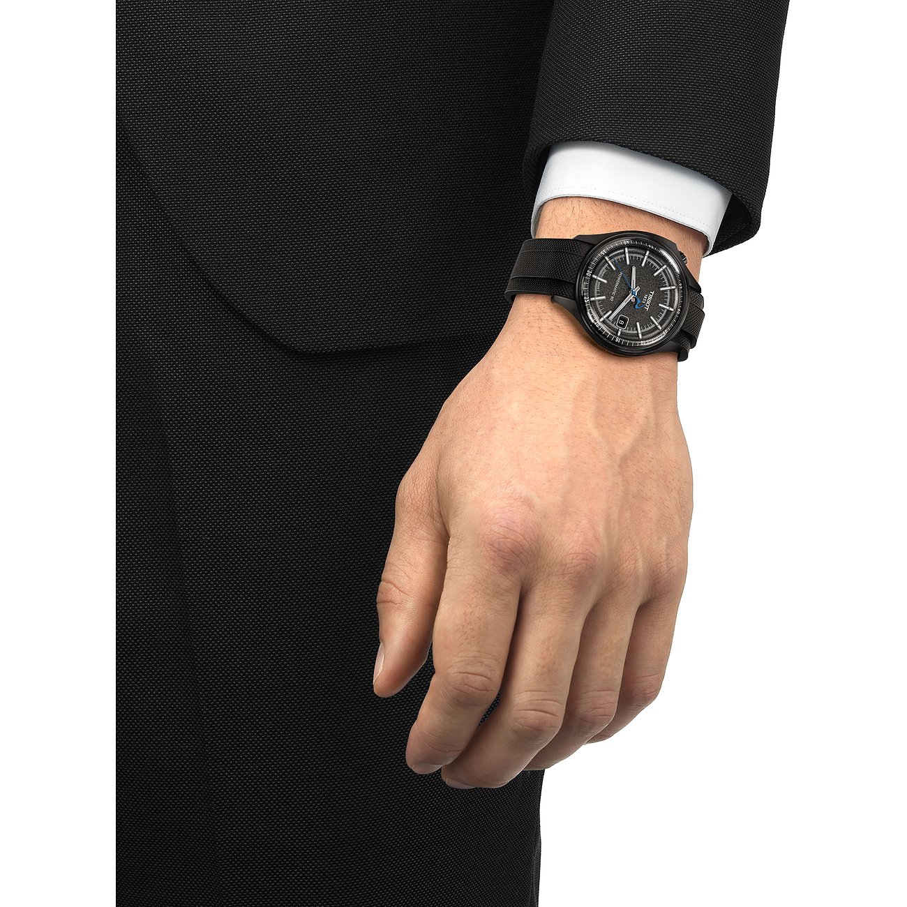 Nahaufnahme einer Tissot Herrenuhr aus Edelstahl am Handgelenk eines Mannes, der einen formellen Anzug trägt.